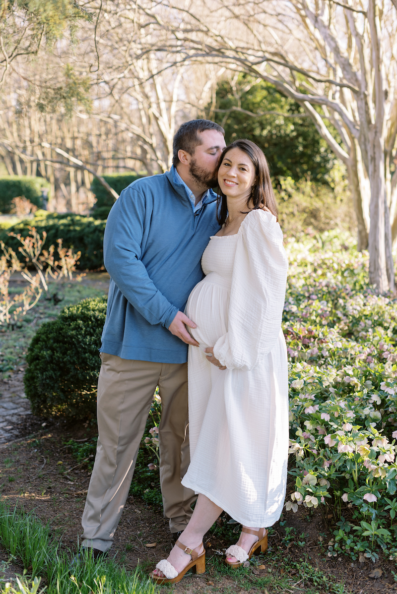 Richmond-maternity-photographer-pregnant couple in garden, husband kissing wife on cheek