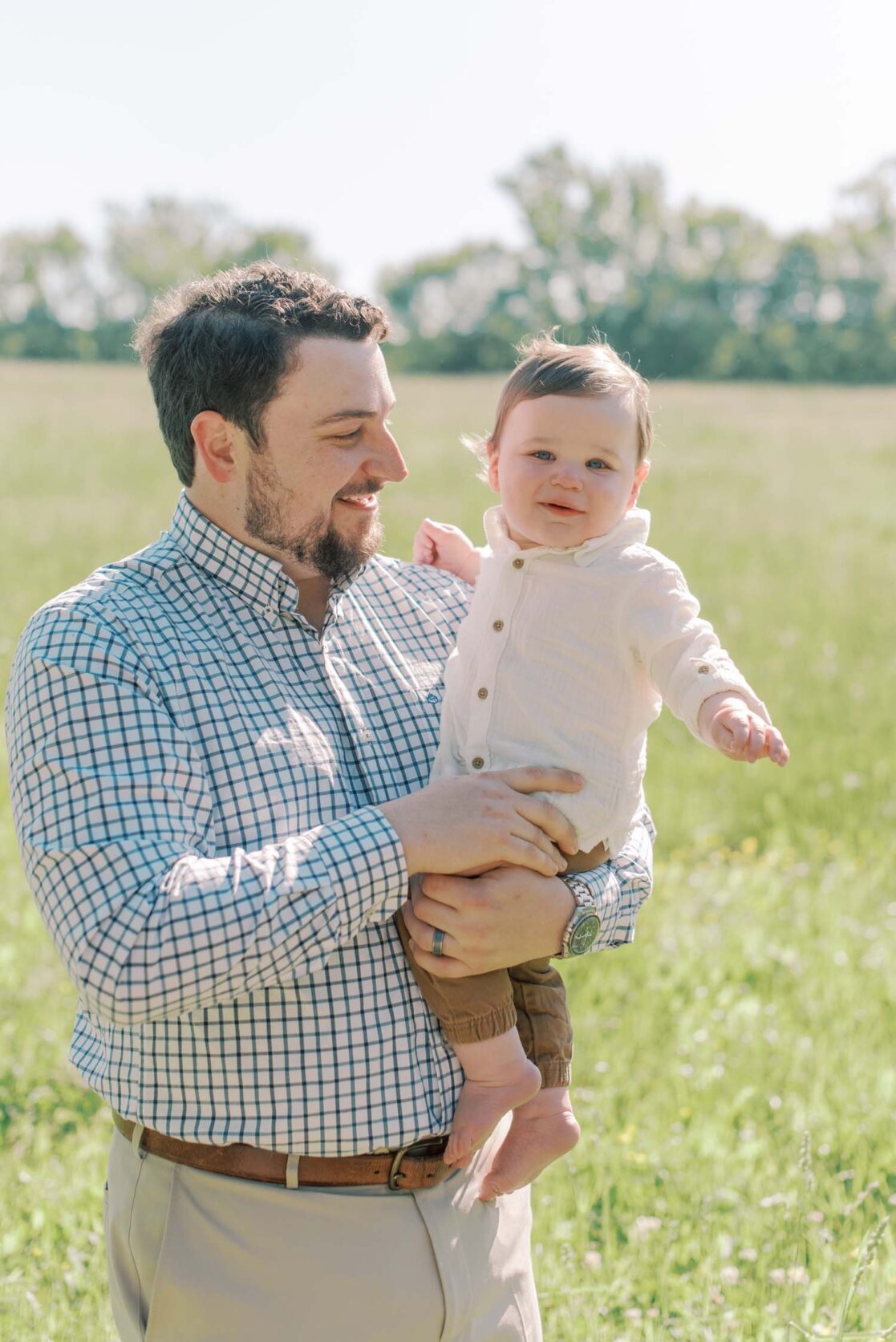 Photo of dad holding baby son in a field by Richmond baby photographer Jacqueline Aimee Portraits