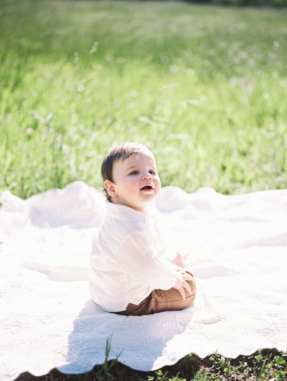 Photo one year old baby boy sitting on a blanket in a field by Richmond baby photographer Jacqueline Aimee Portraits