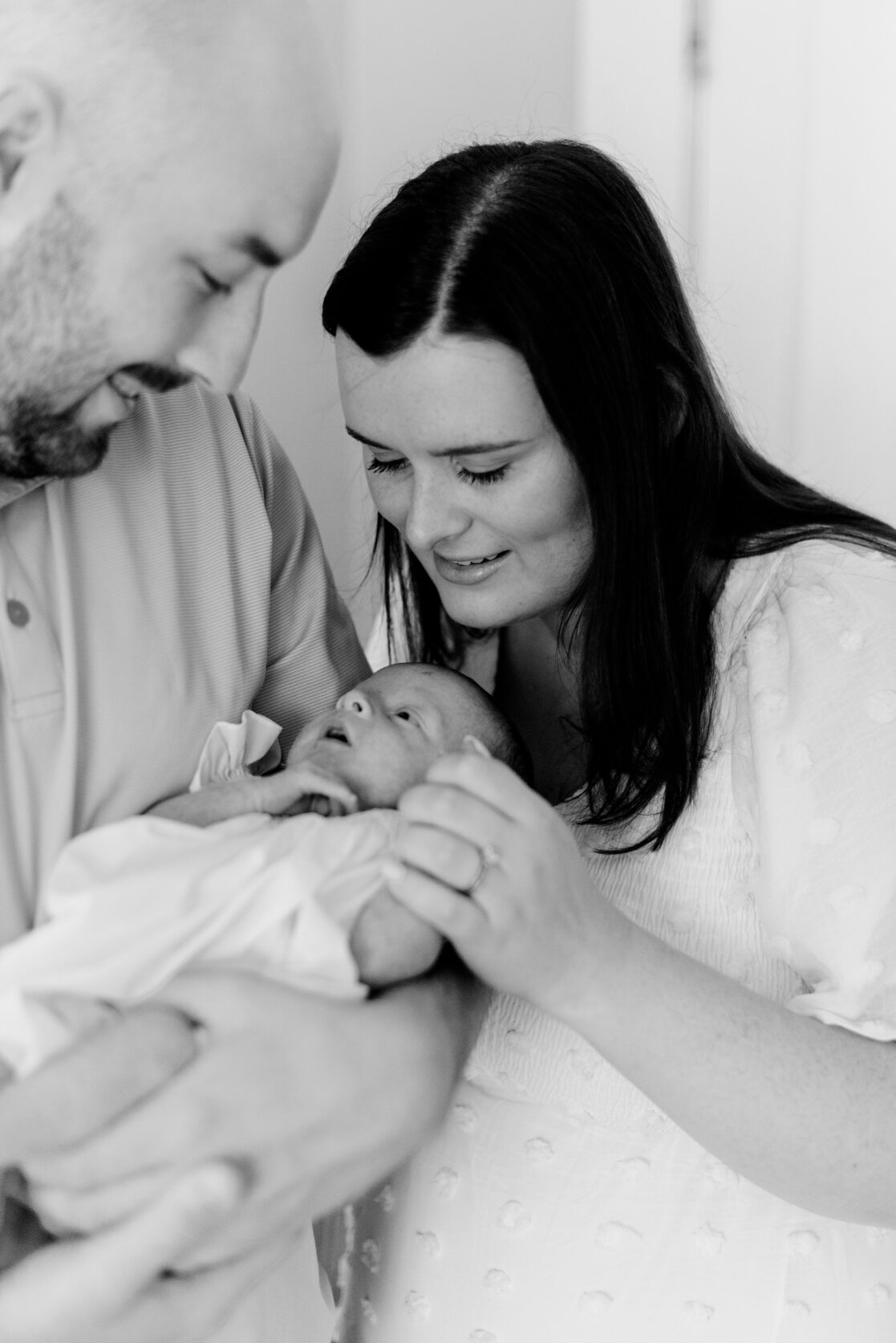 black and white portraits of parents holding newborn