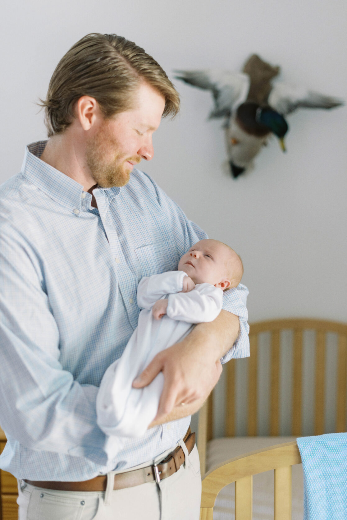 Key poses for newborn photos | Light and airy photo of a dad holding his sleeping newborn baby son by Richmond newborn photographer Jacqueline Aimee Portraits