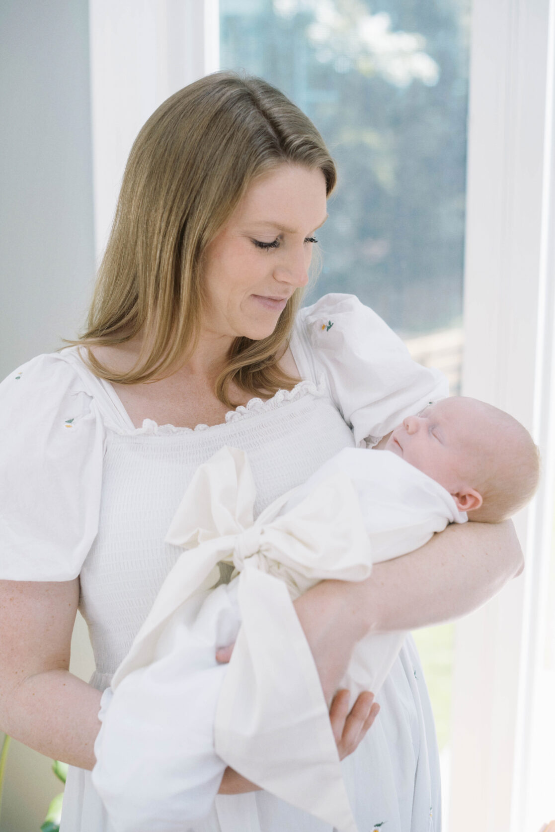 Key poses for newborn photos | Light and airy photo of a mother holding her sleeping newborn baby in her arms by Richmond newborn photographer Jacqueline Aimee Portraits