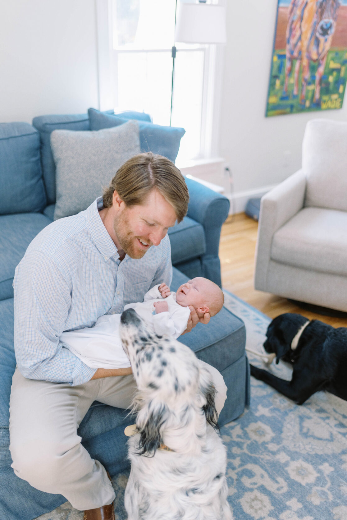 Key poses for newborn photos | Light and airy photo of a father showing the family dog their newborn baby son by Richmond newborn photographer Jacqueline Aimee Portraits