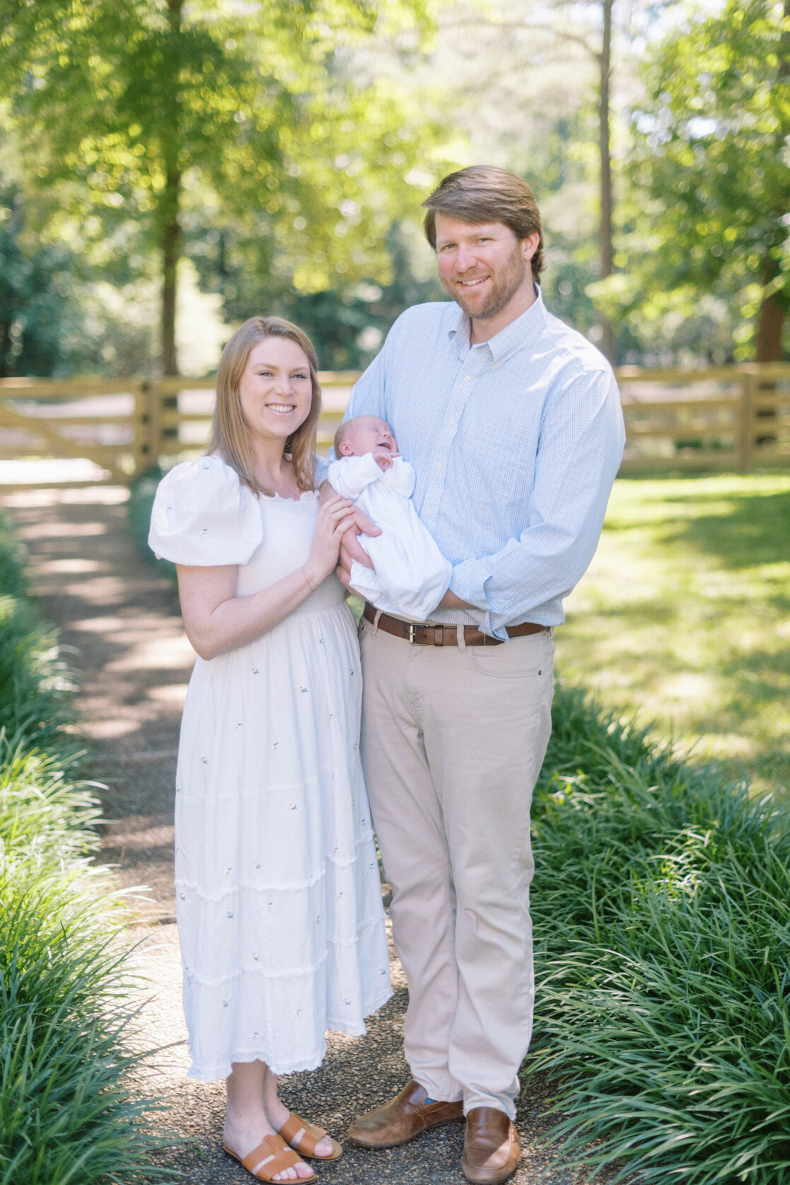 Key poses for newborn photos | Light and airy photo of a family composed of a mother, father and newborn baby, outside in their lush green backyard by Richmond newborn photographer Jacqueline Aimee Portraits