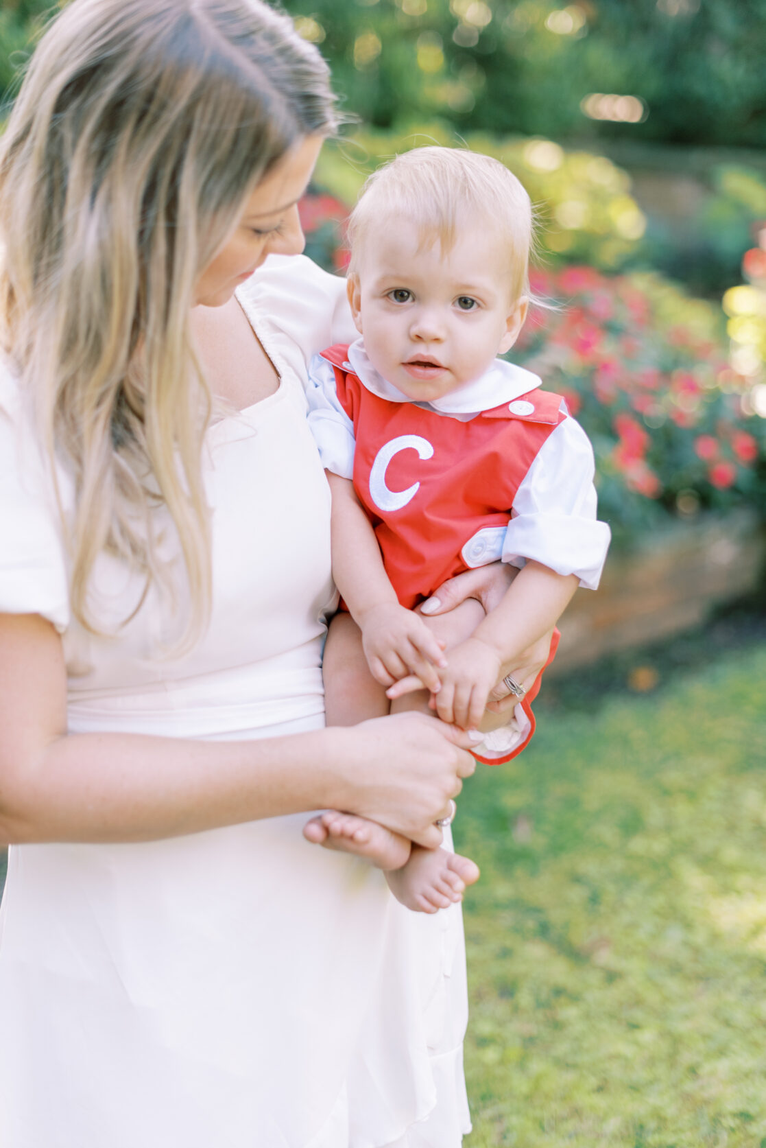 Photo of a mother in a white dress holding her son in a red monogrammed outfit during their richmond fall mini session with jacqueline aimee portraits