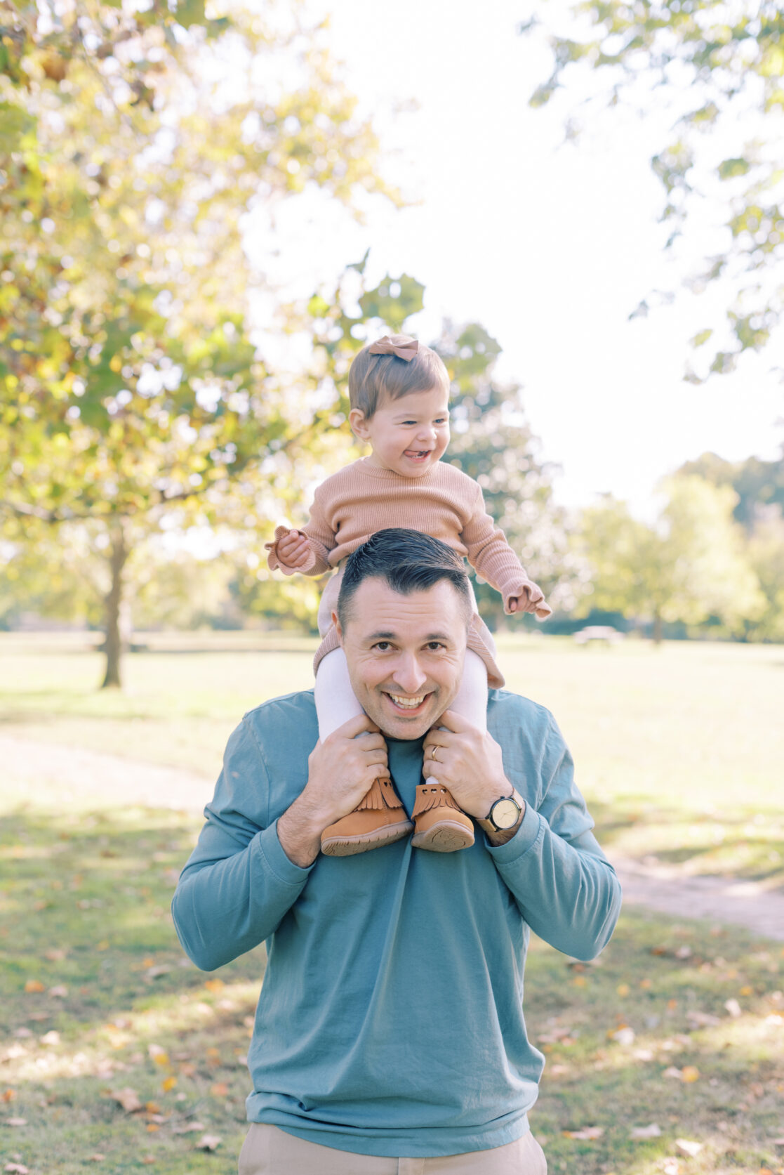 Photo of a toddler girl riding on her dad's shoulders amongst the fall foliage during their richmond fall mini session with jacqueline aimee portraits