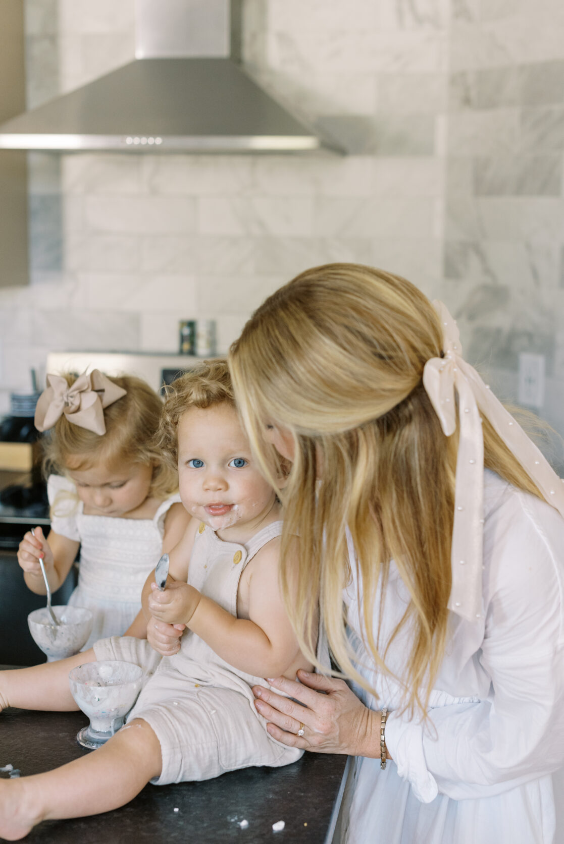 Mom with a creme bow in her hair snuggling with baby son during fun family photos in Richmond by Jacqueline Aimee Portraits 