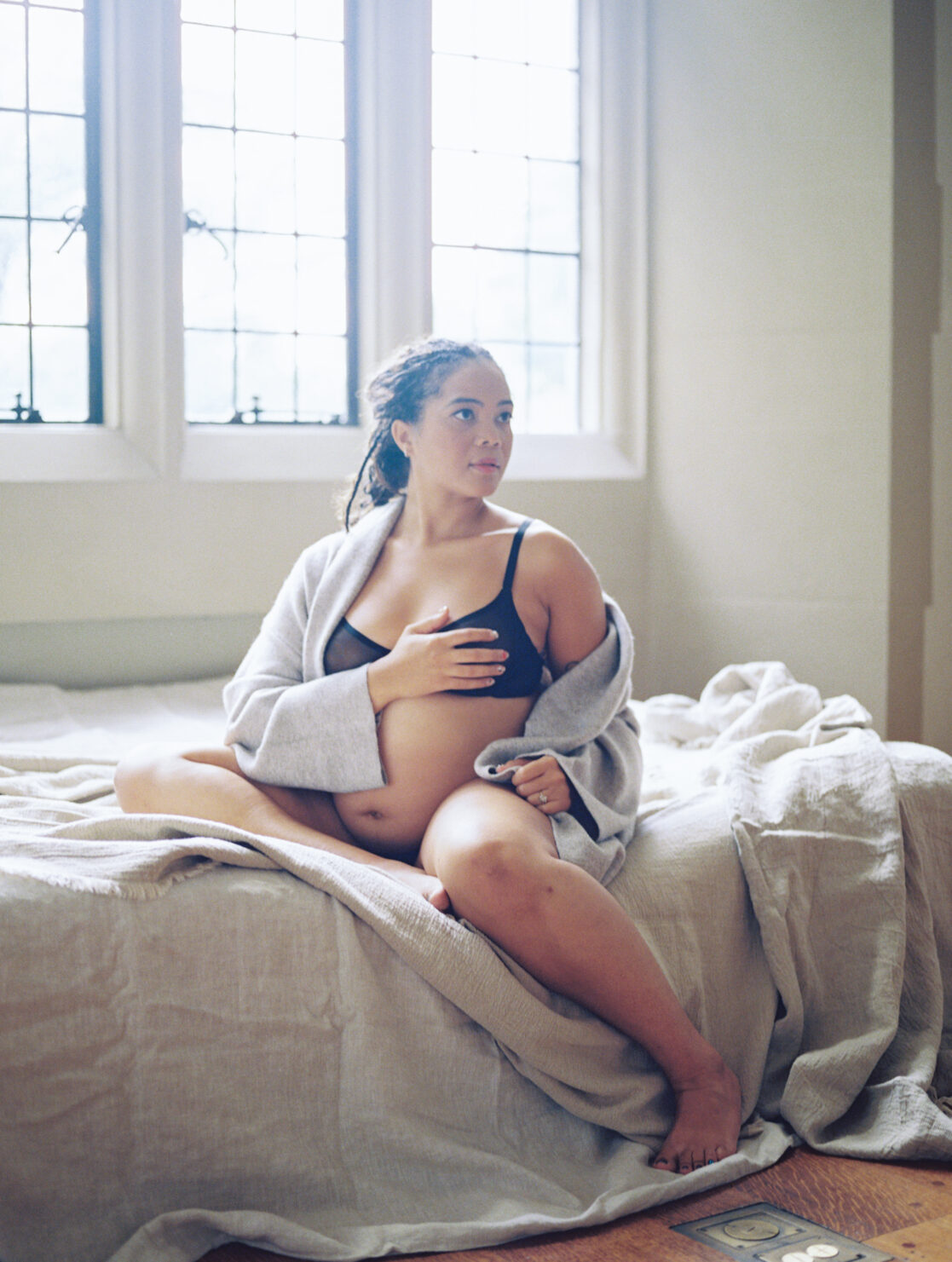 Spas for pregnant women in Richmond | Film photo of a pregnant mother, cozy in a knit cardigan with her belly exposed. 