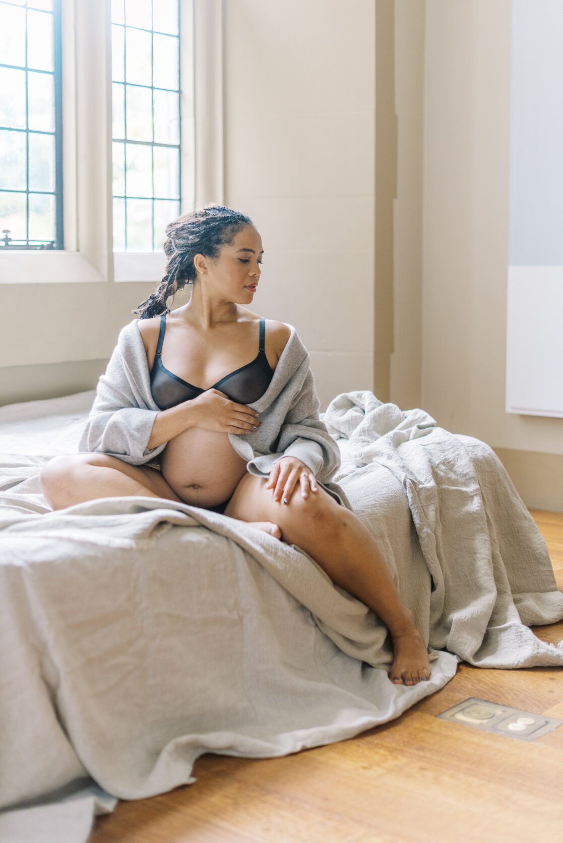 Spas for pregnant women in Richmond | Photo of a pregnant mother, cozy in a knit cardigan with her belly exposed. 