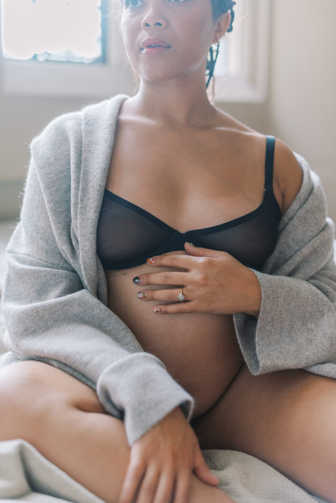 Spas for pregnant women in Richmond | Photo of a pregnant mother, cozy in a knit cardigan with her belly exposed. 