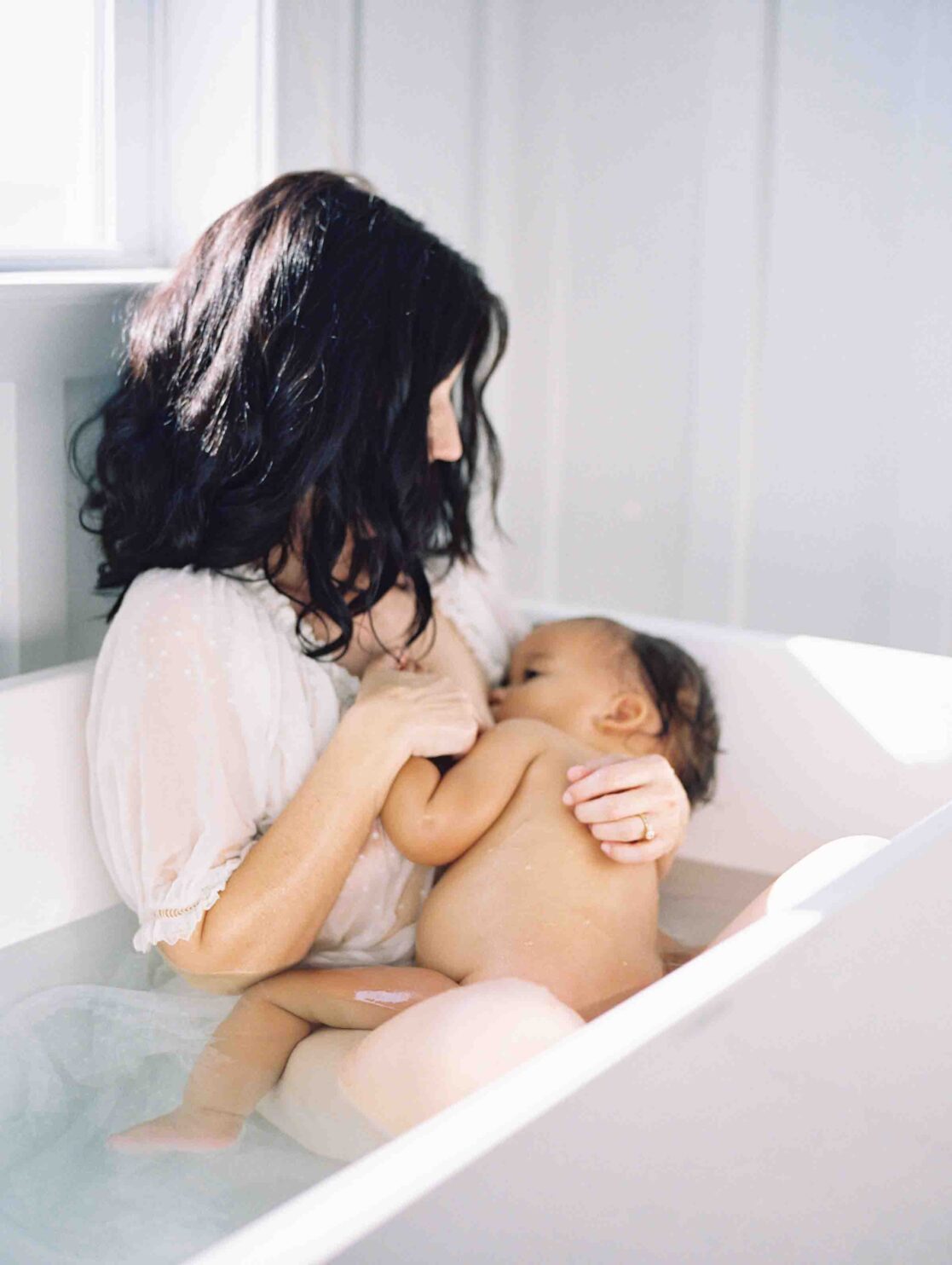 Expert pediatricians in Richmond | Film Photo of a mother breastfeeding her baby girl in a bathtub by Richmond newborn photographer Jacqueline Aimee Portraits