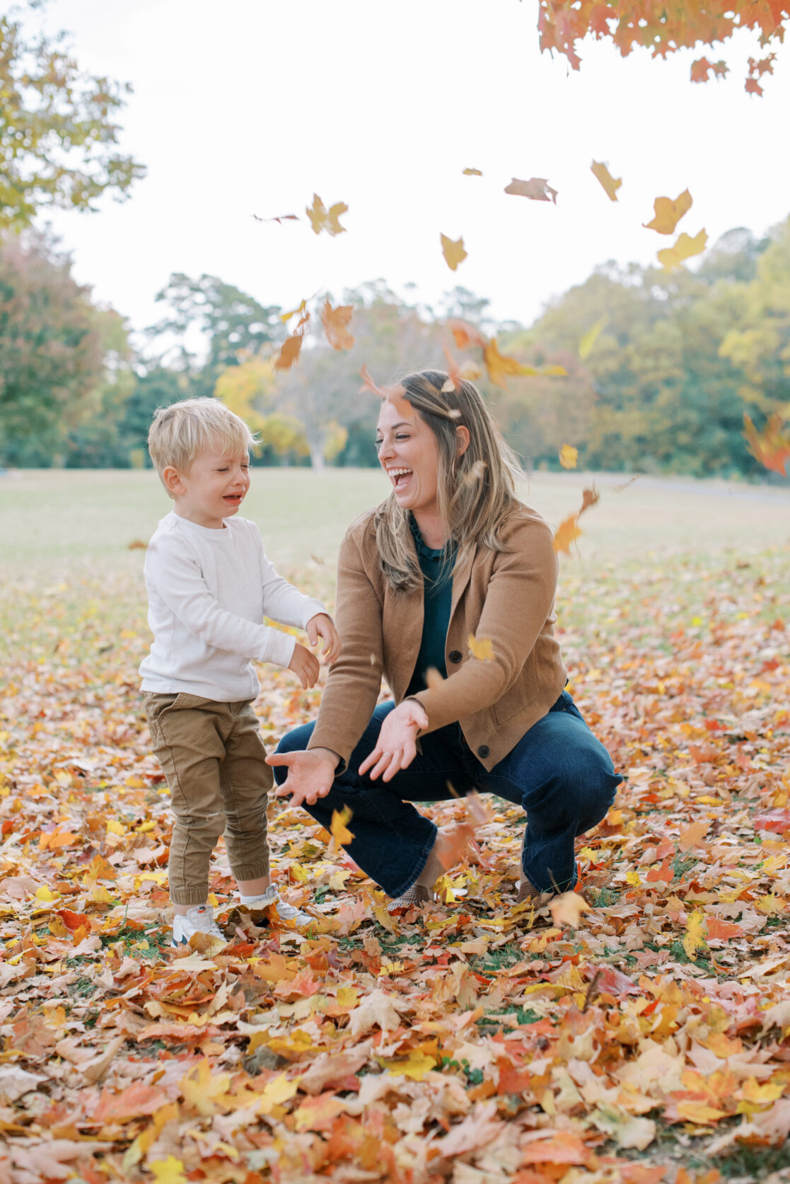 Richmond VA Fall Family Photos | aA mother plays with her young son in the autumn leaves