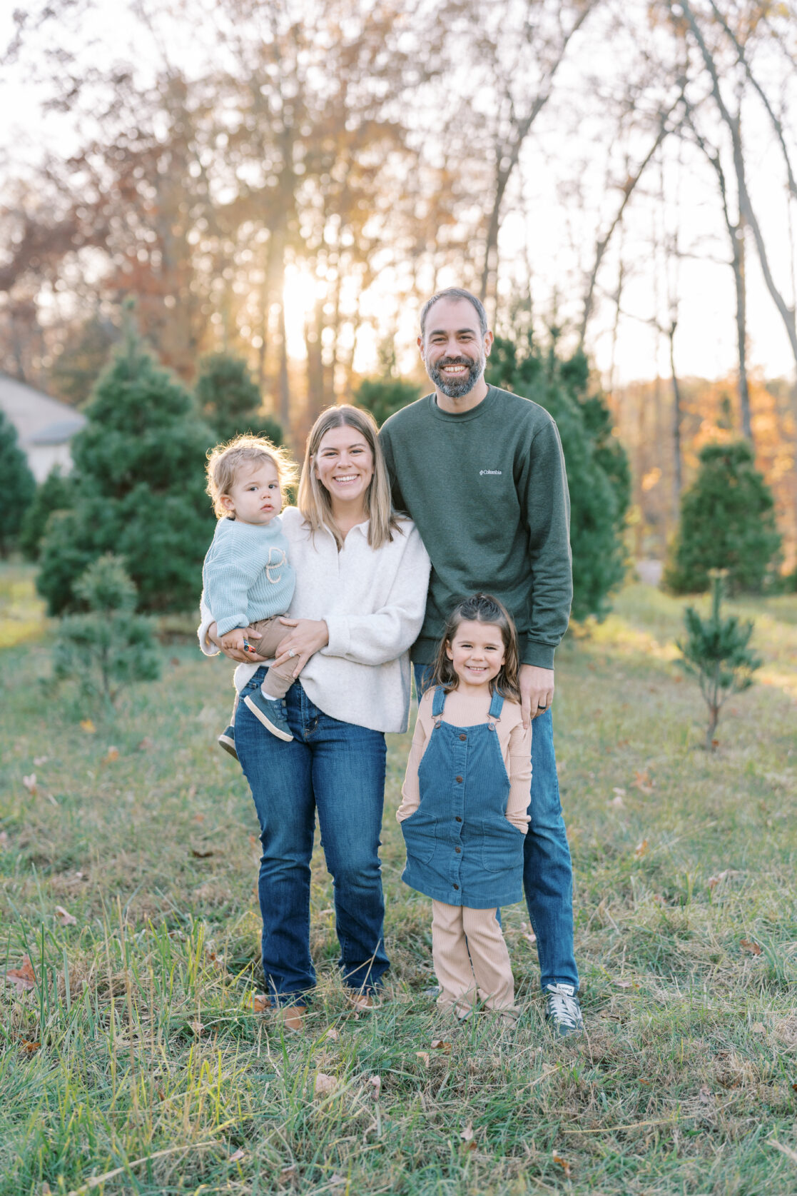 Holiday events for toddlers in Richmond, Virginia - Family enjoys time together, smiling at the camera at a Christmas tree farm in Powhatan. 