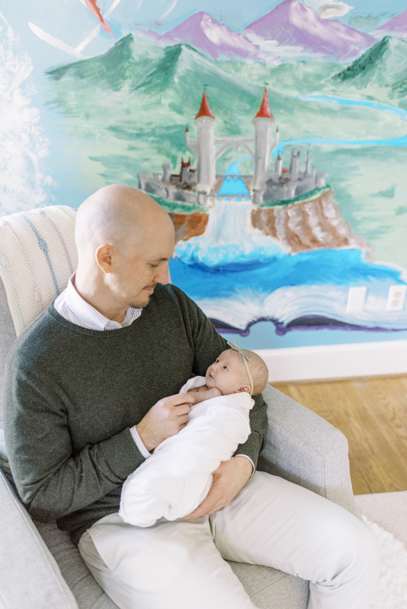 father holding baby in fairy-tale-themed nursery
