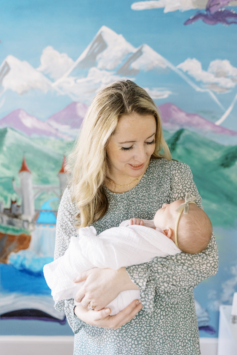mother holding baby in fairy-tale-themed nursery