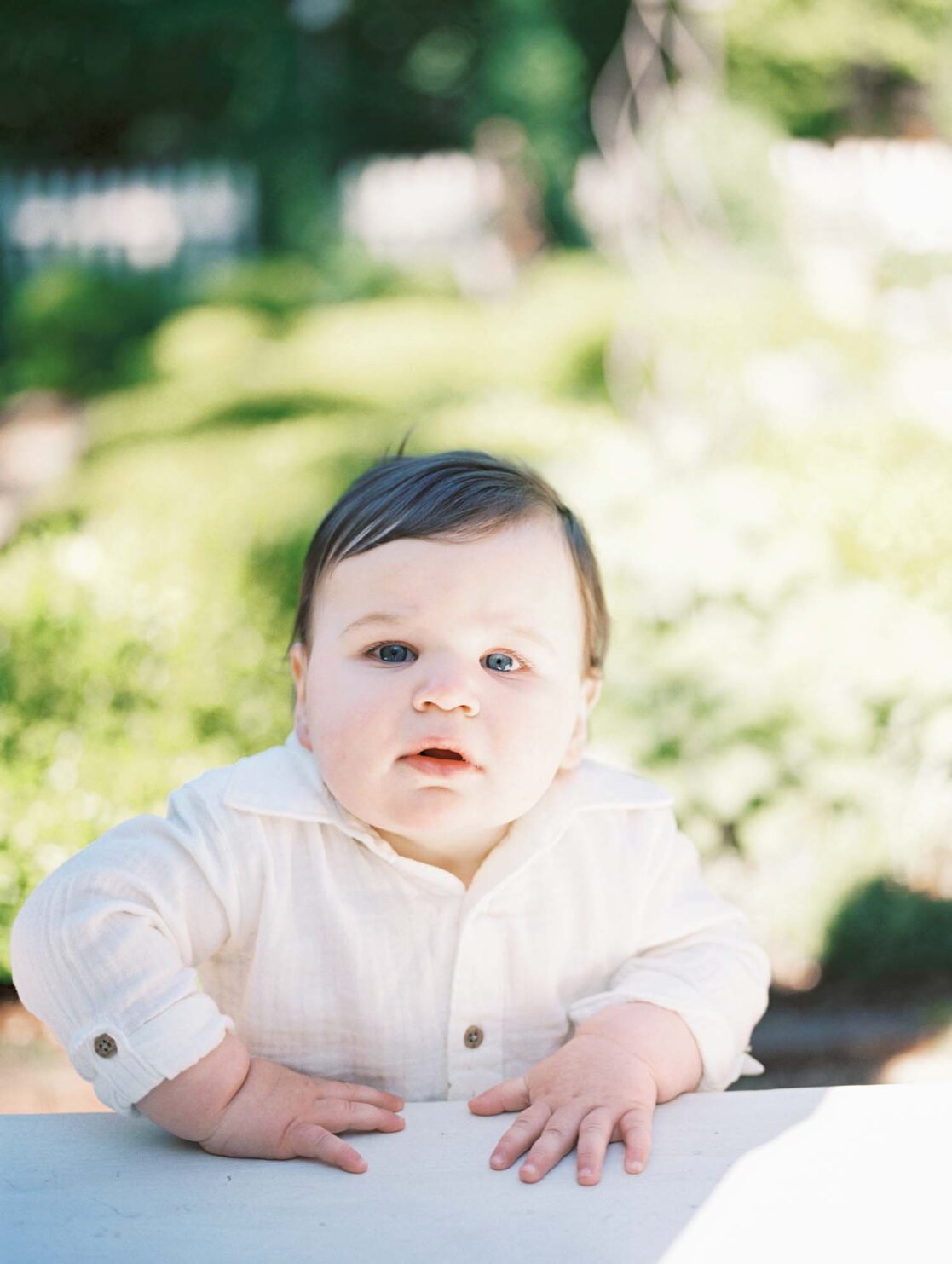 One year old baby boy holding himself up by Richmond baby photographer Jacqueline Aimee Portraits
