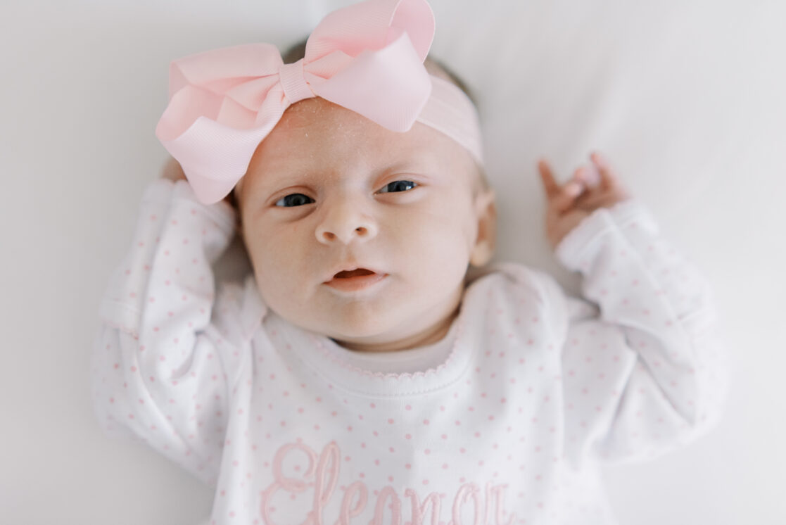 newborn baby closeup with pink bow