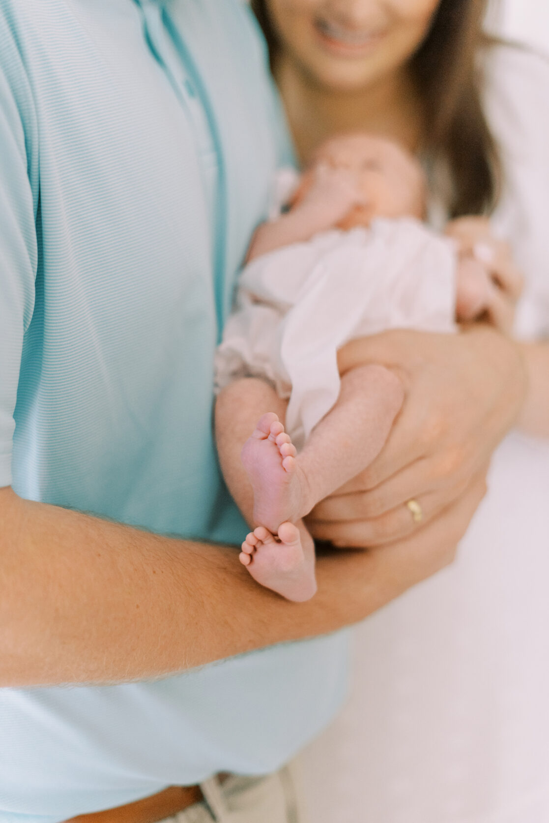 parents holding newborn baby closeup